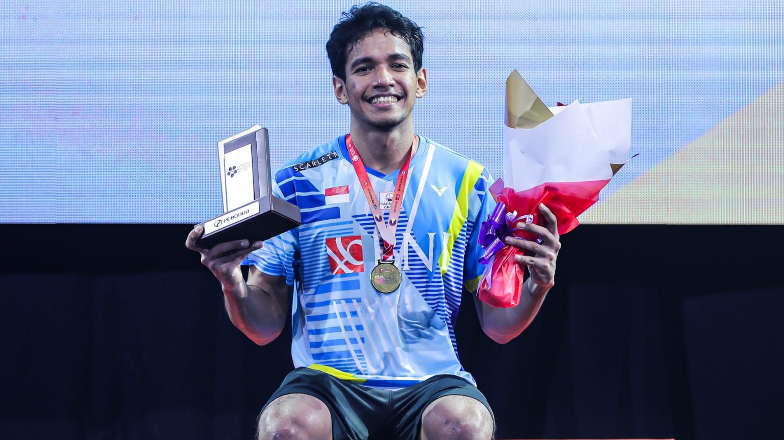 Tunggal putra Indonesia, Chico Aura Dwi Wardoyo, tersenyum saat duduk di podium juara Malaysia Masters 2022 usai memenangi laga final yang digelar di Axiata Arena, Kuala Lumpur pada Minggu (10/7/2022).