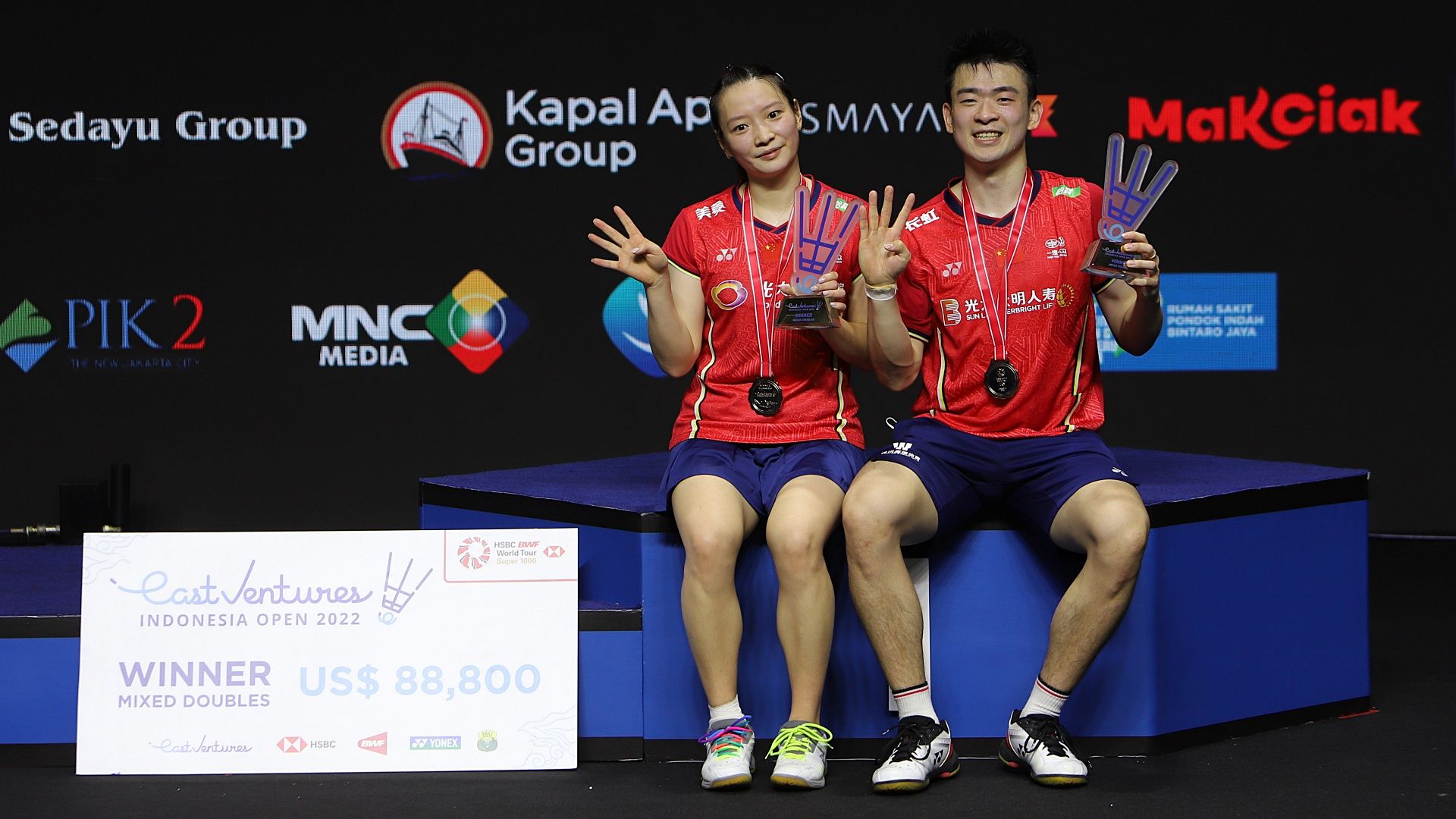 Zheng Si Wei/Huang Ya Qiong duduk di podium juara Indonesia Open 2022 dengan pose gestur tangan angka empat. Gestur itu menggambarkan jumlah gelar juara yang berhasil mereka raih dalam empat turnamen terakhir, yakni Kejuaraan Asia, Thailand Open, Indonesia Masters, dan Indonesia Open.