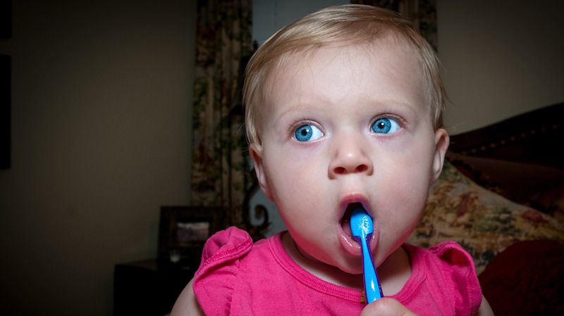 Ilustrasi anak kecil menyikat gigi.