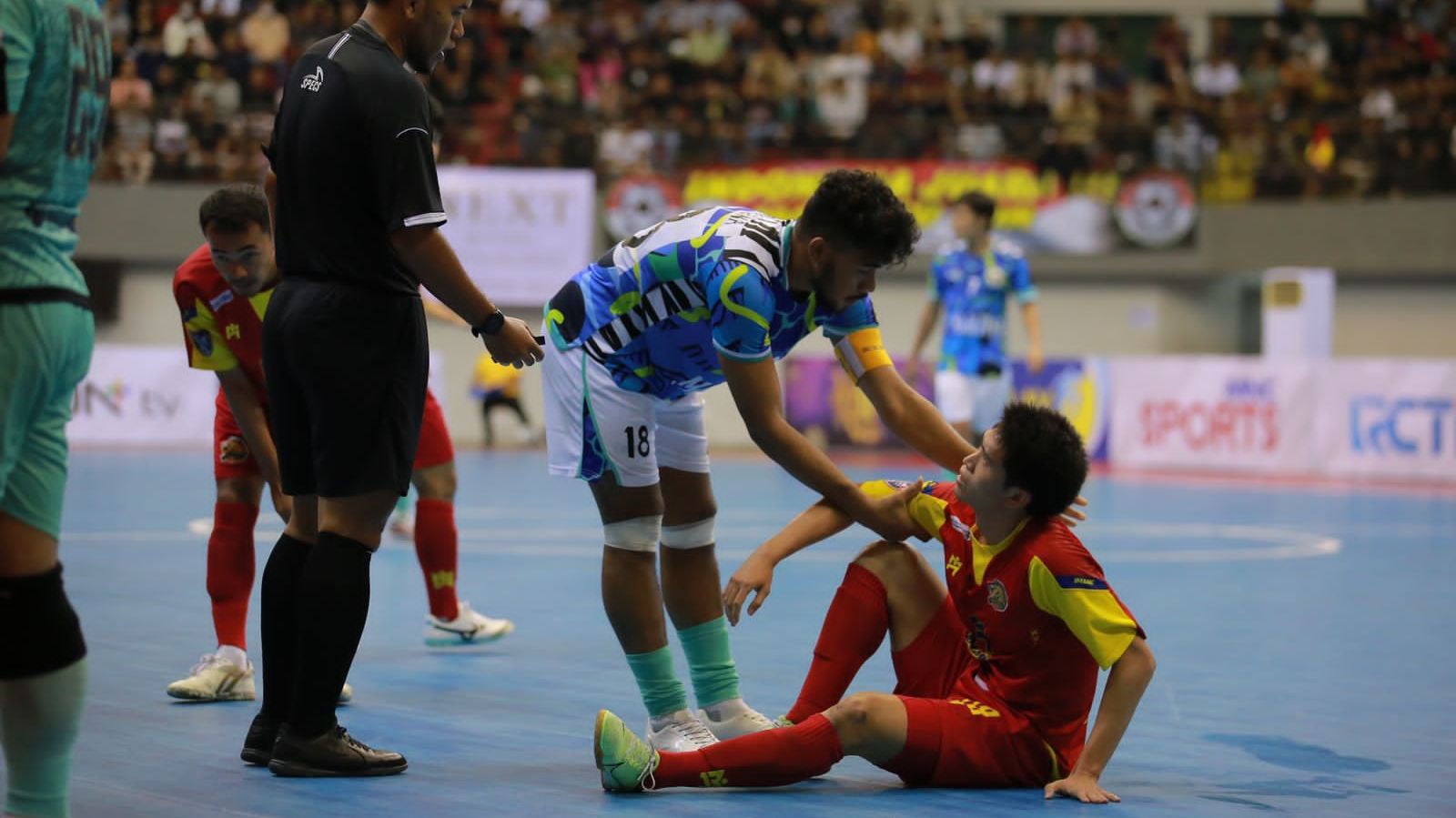 Evan Soumilena sedang membantu pemain lawan bangun saat timnas futsal Indonesia melawan Thammasat Stallion pada MNC International Futsal Cup 2022 di GOR Amongrogo, Yogyakarta, September 2022.
