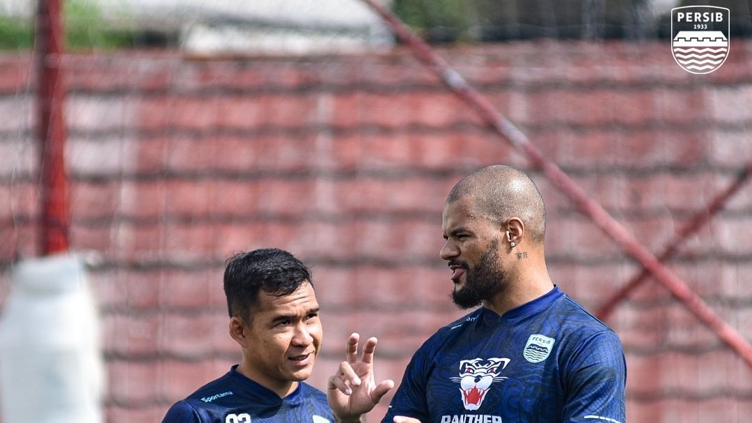 Striker asing anyar Persib, David da Silva berbincang dengan Erwin Ramdani dalam sesi latihan Maung Bandung pada akhir Desember 2021.