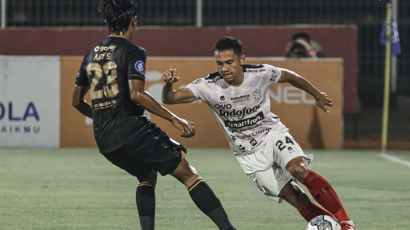 Bek Bali United, Ricky Fajrin berusaha melewati hadangan pemain Persebaya, Ady Setiawan dalam laga tunda putaran pertama Liga 1 2021-2022, 5 Januari 2022.