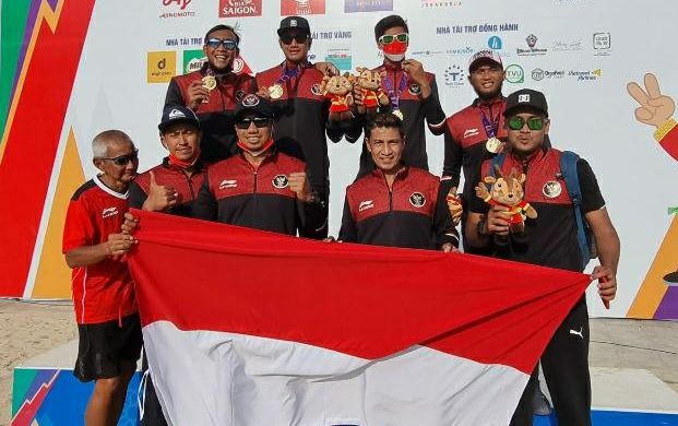 Tim voli pantai putra Indonesia berpose di podium dengan ofisial usai mengamankan medali emas SEA Games 2021 Vietnam, Jumat (20/5/2022).