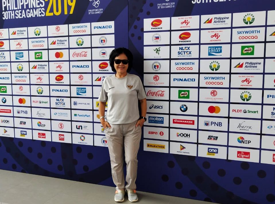 Papat Yunisal berpose di depan banner SEA Games 2019 di Filipina. Ketika itu Papat menjadi anggota Exco PSSI yang ditugaskan menangani sepak bola putri, termasuk timnas.