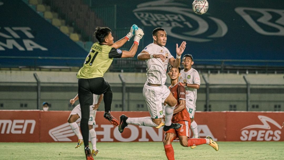 Pemain asing Persebaya Surabaya, Jose Wilkson (putih melompat), berhadapan dengan kiper PSM Makassar, Syaiful Syamsuddin, pada pertandingan pekan ketiga Liga 1 2021-2022, 18 September 2021.