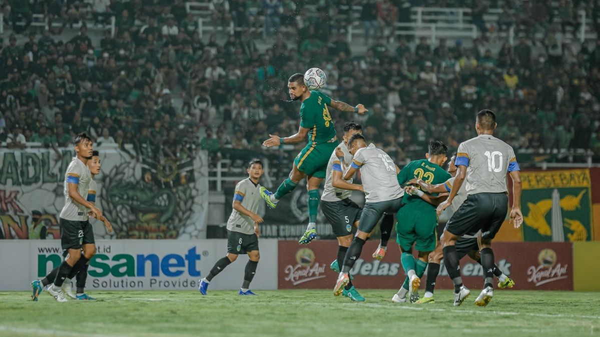 Striker asing Persebaya, Silvio Junior, menyundul bola dalam pertandingan uji coba melawan PSIM Yogyakarta, Minggu (17/7/2022).