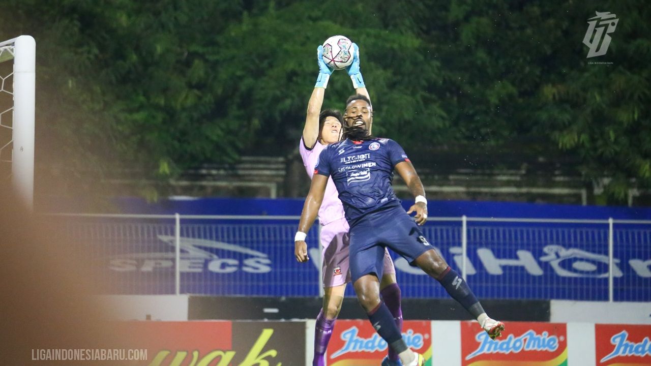 Striker Arema FC, Carlos Fortes berduel dengan kiper Madura United, Hong Jung-nam.