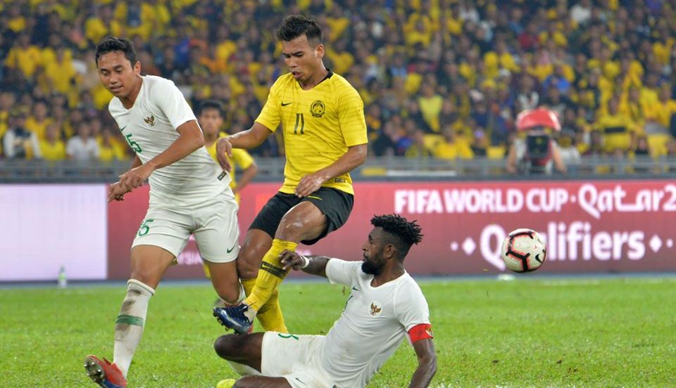 Penyerang timnas Malaysia, Safawi Rasid diapit dua pemain timnas Indonesia, Yanto Basna (terjatuh) dan Ricky Fajrin pada laga Kualifikasi Piala Dunia 2022 di Stadion Nasional Bukit Jalil, Kuala Lumpur, 19 November 2019.