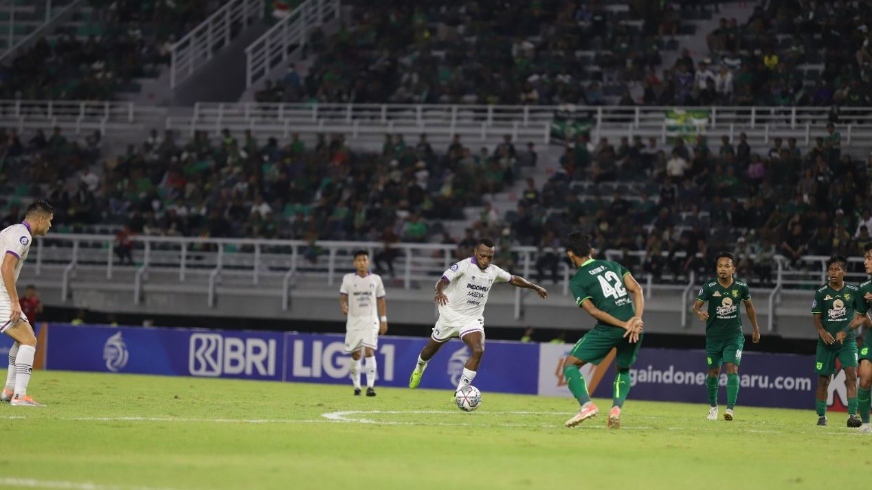 Pemain Persita Tangerang, Elisa Basna (putih) mencoba untuk melepaskan tendangan ke gawang Persebaya Surabaya pada pertandingan pekan kedua Liga 1 2022-2023, di Stadion Gelora Bung Tomo, Surabaya, 1 Agustus 2022.