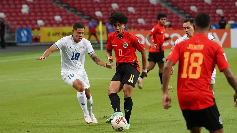 Pemain bertahan Filipina, Kenshiro Daniels (18) mencoba merebut bola dari penyerang Timor Leste, Mouzinho dalam laga fase awal Grup A Piala AFF 2020, 11 Desember 2021.