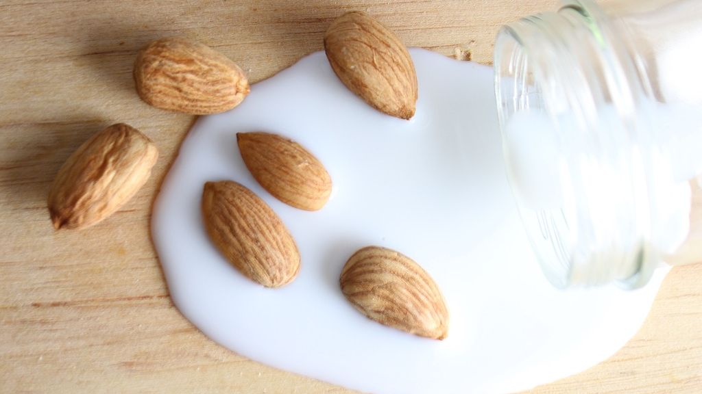 Ilustrasi kacang almond yang dipadukan dengan susu.