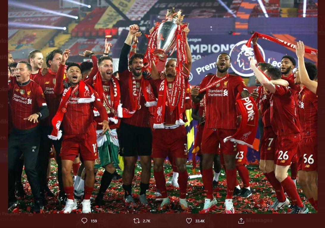 Gelandang Liverpool, Fabinho, mengangkat trofi juara Liga Inggris di stadion yang kosong tanpa penonton.