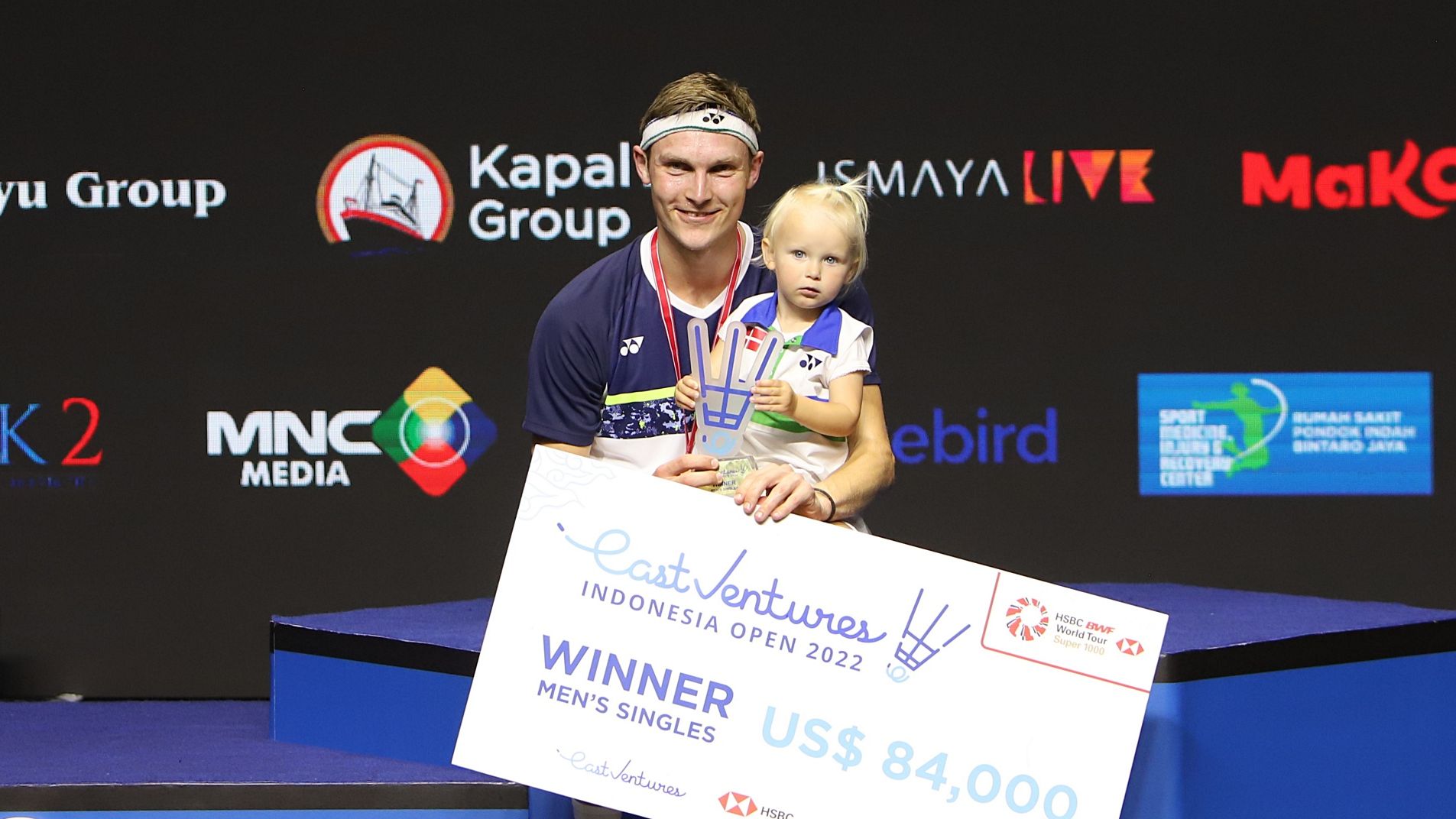 Viktor Axelse duduk di podium juara Indonesia Open 2022 sembari memangku putri tercinta, Vega.