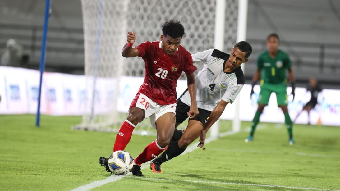 Winger timnas Indonesia, Ramai Rumakiek, mencoba mengecoh pemain Timor Leste.