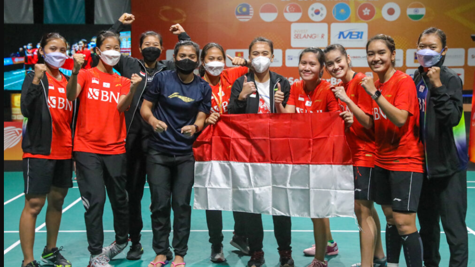 Tim putri Indonesia berpose dengan memegang Bendera Merah Putih usai menjuarai BATC 2022.