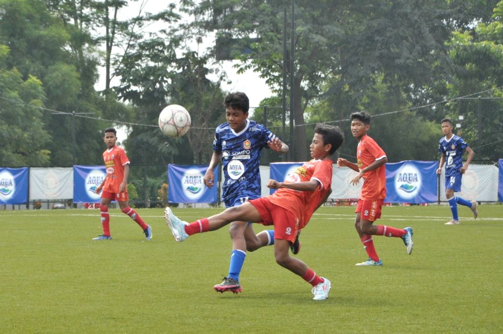 Pemain PFA Sukoharjo (merah) mencoba melindungi bola dari halangan pemain ASIOP (kiri) pada laga final TopSkor Cup Nasional U-14 2022