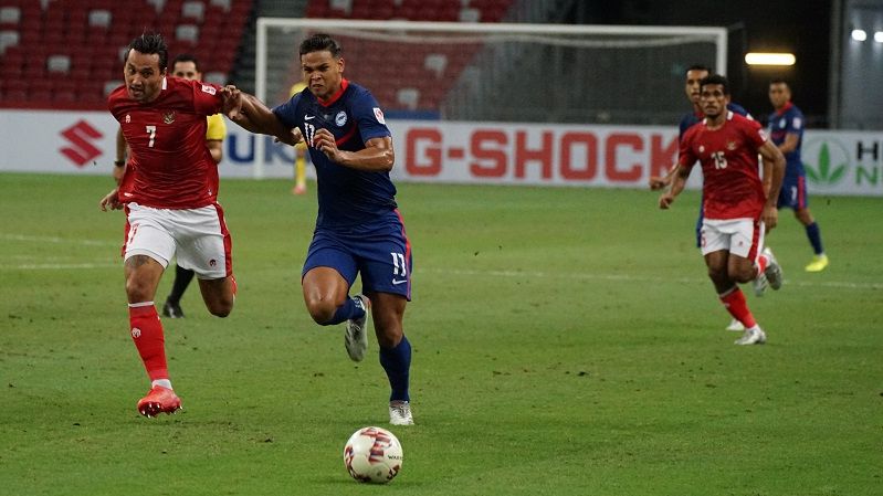 Adu lari antara striker Indonesia, Ezra Walian dan bek tengah Singapura, Irfan Fandi (kanan) dalam laga leg kedua semifinal Piala AFF 2020, 25 Desember 2021.