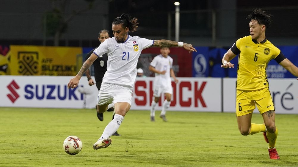 Striker Laos, Billy Ketkeophomphone (21) saat menguasai bola diawasi bek timnas Malaysia, Dominic Tan dalam laga fase awal Grup B Piala AFF 2020, 9 Desember 2021.
