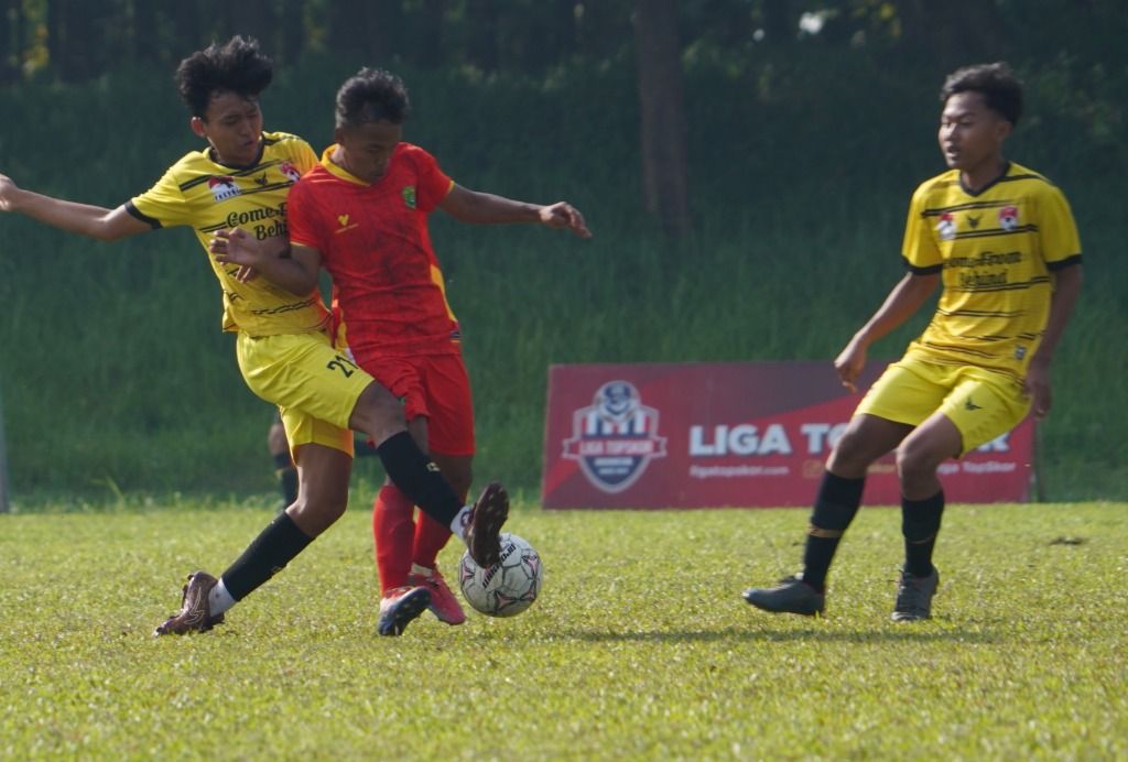 Pemain Diklat ISA (kuning) berusaha untuk mencuri bola dari penguasaan pemain Pesik Kuningan (merah) pada partai final TopSkor Cup Nasional U-18 2022