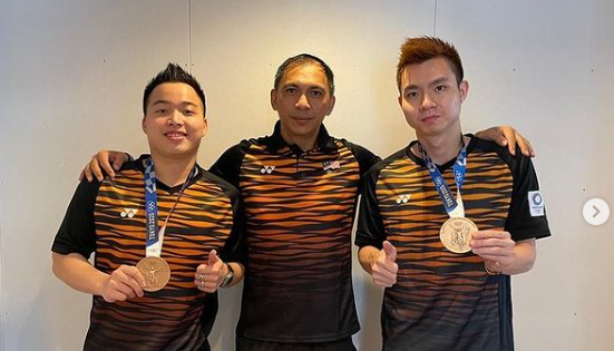 Aaron Chia (kiri) dan Soh Wooi Yik (kanan) berpose dengan pelatih Flandy Limpele (tengah) usai merebut medali perunggu Olimpiade Tokyo 2020.