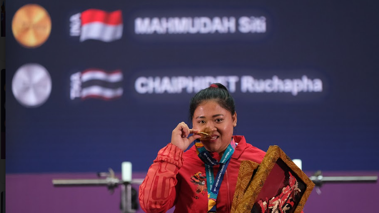 Atlet para powerlifting Indonesia, Siti Mahmudah, menggigit medali usai dipastikan menjadi juara kelas -79kg putri di ASEAN Para Games 2022.