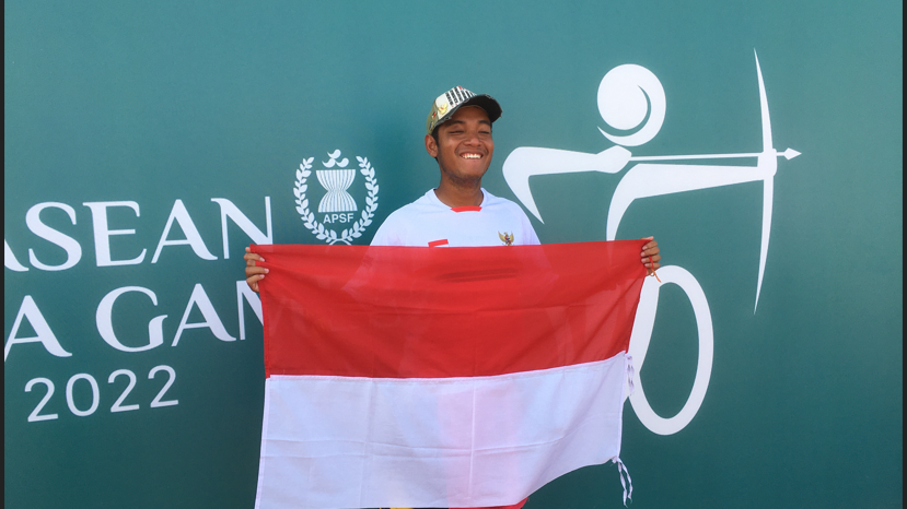 Atlet para panahan Indonesia, Ken Swagumilang, berpose dengan bendera Merah Putih usai menyumbang medali perunggu di ASEAN Para Games 2022, Kamis (4/8/2022).