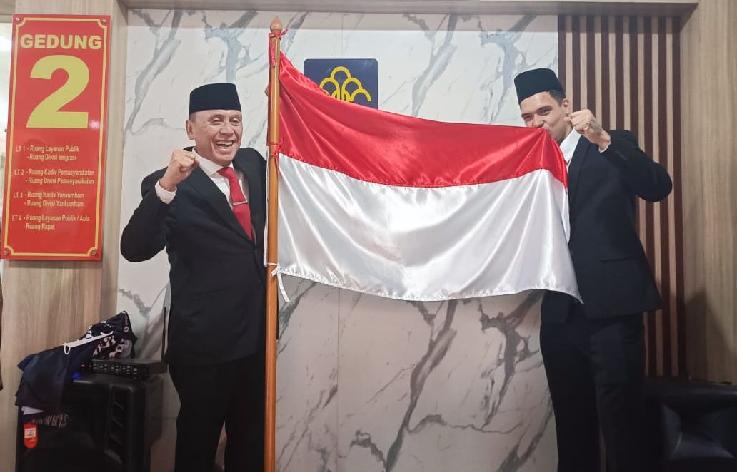 Shayne Pattynama (kanan) mencuim bendera Indonesia usai resmi menjadi WNI, Selasa (24/1/2023).