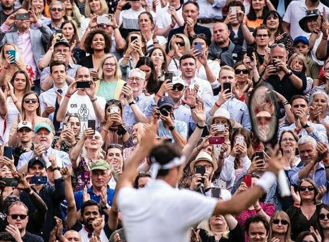 Penonton di All England Club mengabadikan Roger Federer usai memastikan tiket perempat final Wimbledon 2021.  