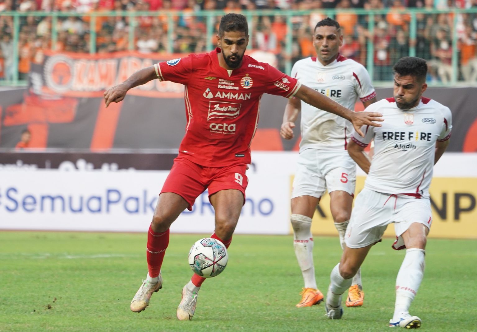 Abdulla Yusuf Helal membela Persija Jakarta (merah), mencoba menguasai bola dari penjagaan para pemain Persis Solo pada pekan kedua Liga 1 2022-2023, di Stadion Patriot Candrabagha, Bekasi, 31 Juli 2022.