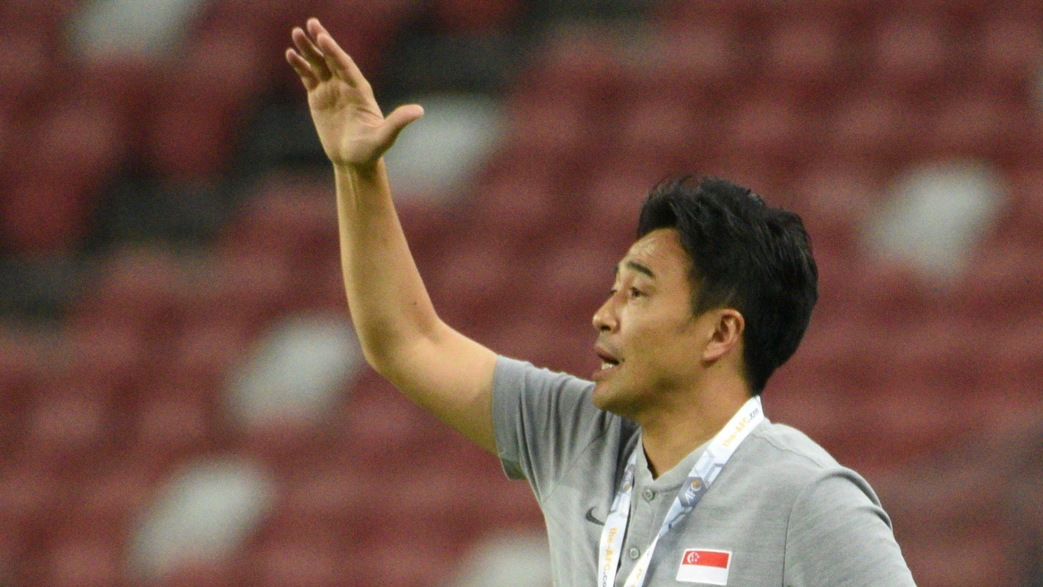 Tatsuma Yoshida memimpin timnas Singapura dari pinggir lapangan.