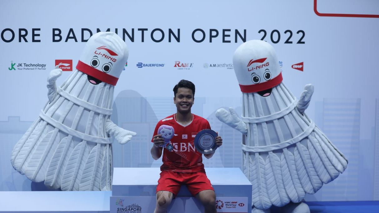 Tunggal putra Indonesia, Anthony Sinisuka Ginting, duduk di podium kemenangan usai menjuarai Singapore Open 2022 yang menggelar laga finalnya di Singapore Indoor Stadium pada Minggu (17/7/2022).