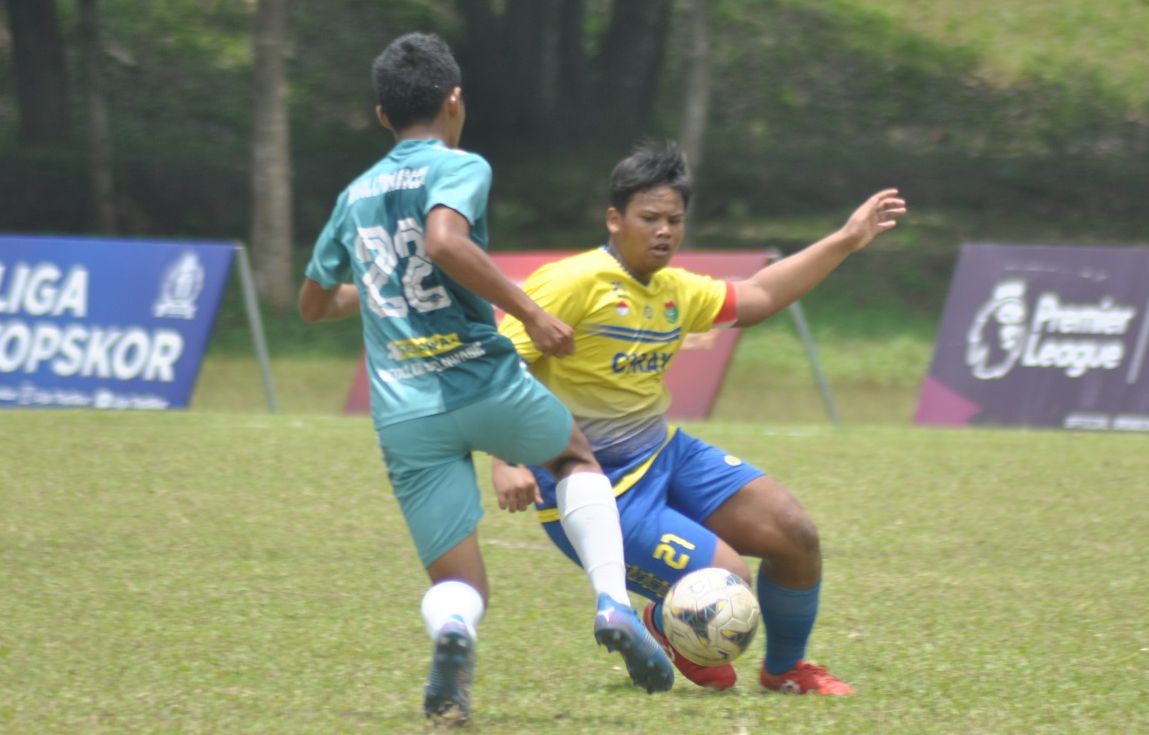 Penyerang Revolution Soccer mendapat hadangan dari pemain lini pertahanan Cibinong Raya di Liga TopSkor U-14 2022-2023.