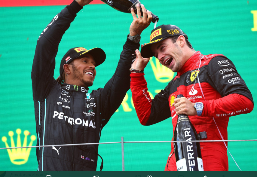 Pembalap Tim Mercedes-AMG Petronas Lewis Hamilton (kiri) menyiramkan sampanye ke arah pembalap Scuderia Ferrari Charles Leclerc di podium sebuah balapan F1 pada 2022 lalu.